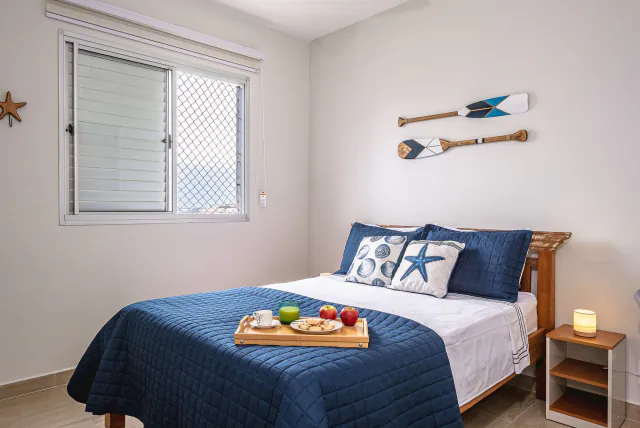 Quarto arrumado para o hóspede, com bandeja de boas-vindas sobre a cama