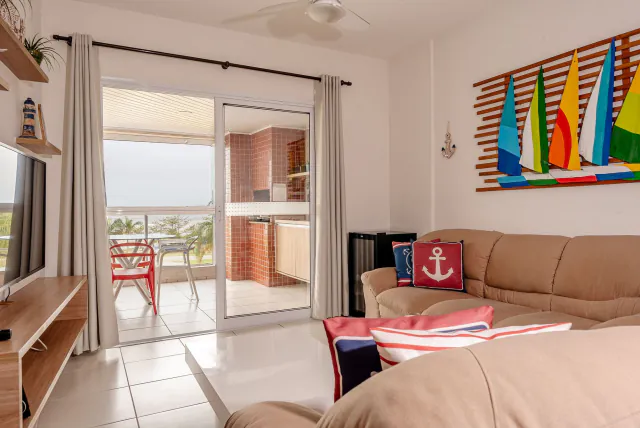 Sala do apartamento frente mar no Indaiá, com a varanda ao fundo