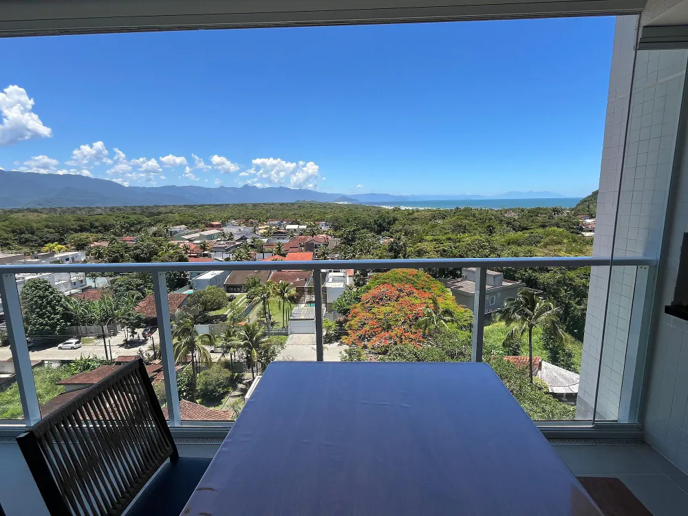 Varanda de um apartamento ao lado da Riviera, com a mata e o mar de Bertioga ao fundo